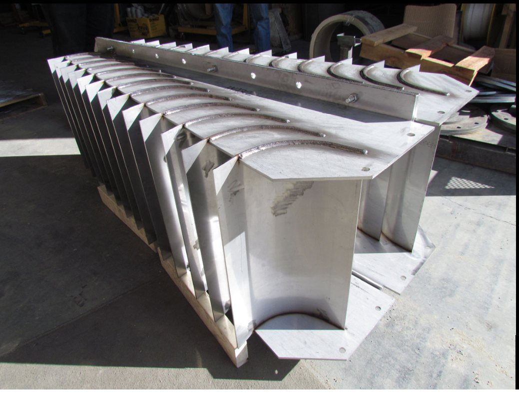 A fabricated stainless inlet device with vaned outlet.