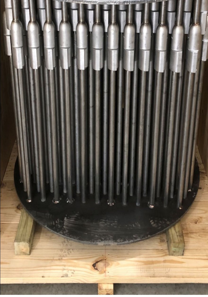 A completed tubesheet bundle crated on dunnage, tubes rolled into the sheet.